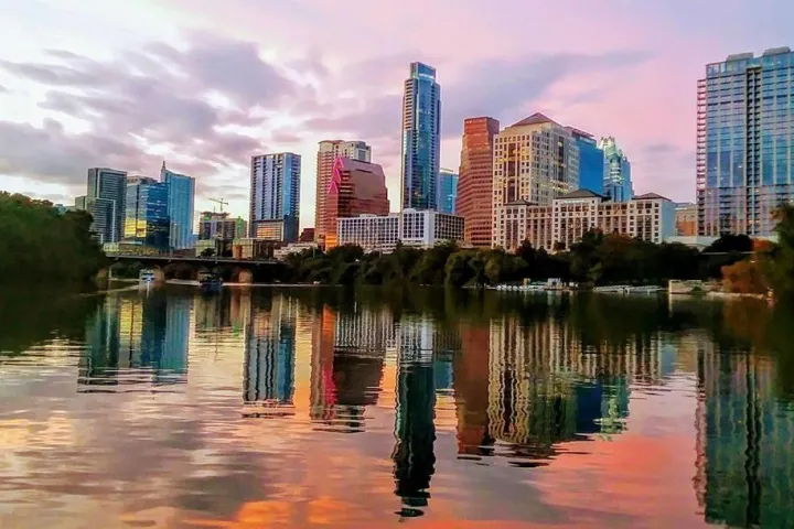 a bridge over a body of water with a city in the background