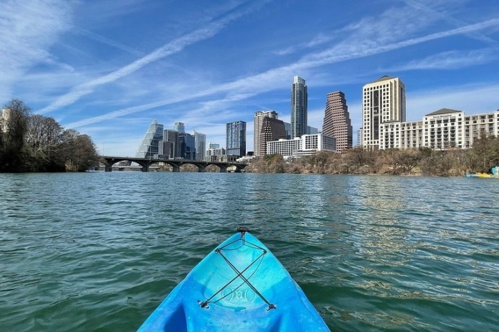 a boat on a body of water with a city in the background