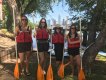 Four women with life vests and paddles