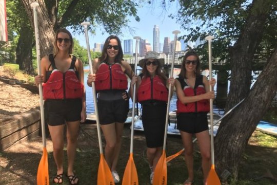 Four women with life vests and paddles